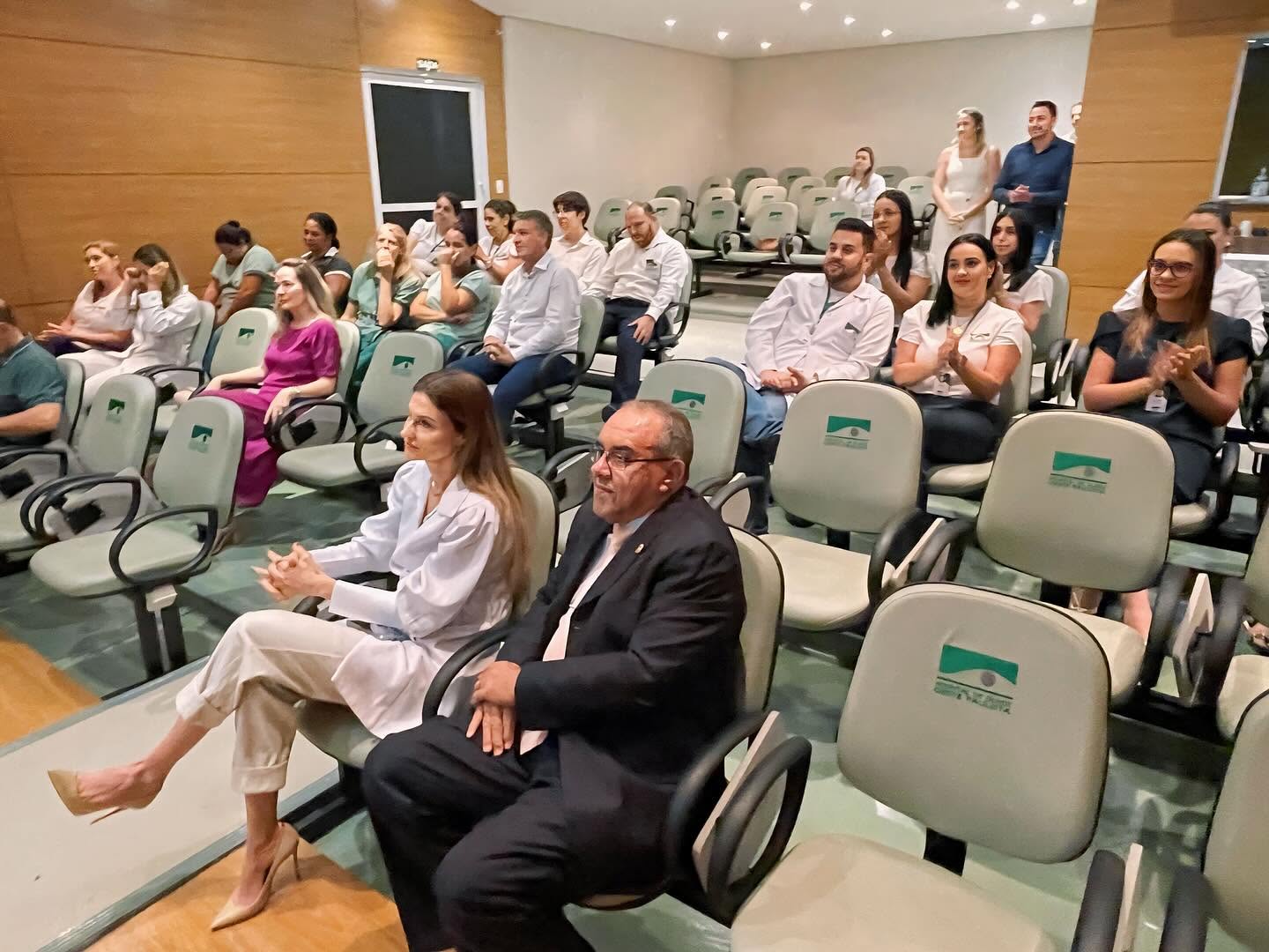 Profissionais e participantes em evento no anfiteatro